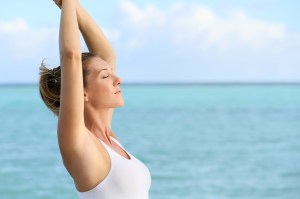 Portrait of fitness woman stretching out by the sea